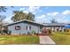 Gray house with metal roof, landscaped yard, and lake view at 10455 Se 143Rd St, Summerfield, FL 34491