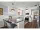 L-shaped kitchen island with granite countertops and modern pendant lighting at 10455 Se 143Rd St, Summerfield, FL 34491