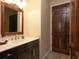 Bathroom with dark vanity, mirror, and a wooden door at 11130 W Highway 326, Ocala, FL 34482