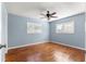 Blue bedroom with wood flooring, ceiling fan and access to bathroom at 11250 Sw 79Th Ter, Ocala, FL 34476