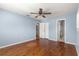 Blue bedroom with wood floors, ceiling fan and bathroom access at 11250 Sw 79Th Ter, Ocala, FL 34476