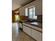 Kitchen with white cabinets, tile counters, and double sink at 13981 Se 86Th Cir, Summerfield, FL 34491