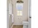 Small bathroom with shower, toilet, and window at 17385 Se 110Th Ter, Summerfield, FL 34491