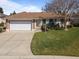 Single-story home with attached garage and well-maintained lawn at 17385 Se 110Th Ter, Summerfield, FL 34491