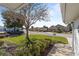 Peaceful street view with a mature tree and neatly trimmed hedges at 17385 Se 110Th Ter, Summerfield, FL 34491