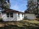 White single story home with brown roof and large windows at 18782 Se 50Th St, Ocklawaha, FL 32179