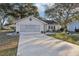 Tan one story house with screened garage and small front yard at 1904 Tweed Ct, Leesburg, FL 34788