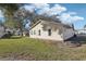 Tan house exterior with a side yard and landscaping at 1904 Tweed Ct, Leesburg, FL 34788