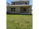 View of the home's backyard with green grass and a covered patio area at 2210 Nw 23Rd Loop, Ocala, FL 34475