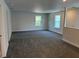Spacious bedroom featuring neutral carpet, natural light, and two windows at 2210 Nw 23Rd Loop, Ocala, FL 34475