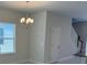 This dining room features a modern chandelier, a window, and access to the staircase at 2210 Nw 23Rd Loop, Ocala, FL 34475