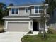 Charming two-story home with a well-maintained lawn and a two car garage on a sunny day at 2210 Nw 23Rd Loop, Ocala, FL 34475