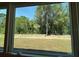 Scenic backyard view framed by a large window, showcasing lush greenery and natural light at 2214 Nw 23Rd Loop, Ocala, FL 34475