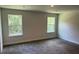 Bright bedroom features plush carpeting, neutral walls, and two windows that offer natural light and outdoor views at 2214 Nw 23Rd Loop, Ocala, FL 34475