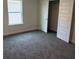 Comfortable carpeted bedroom with a window offering natural light and a closet with mirrored doors at 2214 Nw 23Rd Loop, Ocala, FL 34475