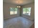 Bright dining room with tile flooring, a modern chandelier, and large windows providing ample natural light at 2214 Nw 23Rd Loop, Ocala, FL 34475