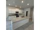 Modern kitchen featuring granite countertops, white cabinetry, stainless steel appliances, and an island with a sink at 2214 Nw 23Rd Loop, Ocala, FL 34475