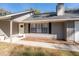 Front entrance with gray siding, white door, and updated landscaping at 43 Teak Crse, Ocala, FL 34472