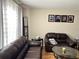 Living room with leather sofas, wood floors, and framed photos at 4517 Se 28Th St, Ocala, FL 34480