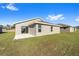 House exterior showcasing a patio, grassy yard, and neutral color scheme at 5 Pine Course Loop, Ocala, FL 34472