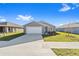 New construction home with gray siding, white garage door, and landscaping at 5 Pine Course Loop, Ocala, FL 34472