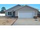 Newly constructed home with a gray exterior, white garage door, and stone accents at 5 Pine Course Loop, Ocala, FL 34472