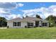 Single-story home with a light-colored facade, dark roof, and neatly landscaped lawn at 5322 Sw 137Th Ct, Ocala, FL 34481