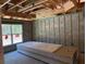 Interior shot of an unfinished room, exposed rafters, block walls, and stacks of sheetrock at 5322 Sw 137Th Ct, Ocala, FL 34481