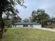 Newly built home with a white exterior, two-car garage, and well-maintained lawn at 5921 Se 4Th Pl, Ocala, FL 34472