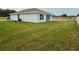 Rear view of a single-story house with a grassy yard at 6574 Se 108Th Ln, Belleview, FL 34420