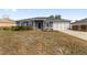 Front view of a gray house with a garage and landscaping at 6695 Sw 64Th Ter, Ocala, FL 34476