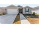 Single-story home with gray siding, white garage door, and landscaping at 7094 Sw 60Th Ln, Ocala, FL 34474