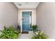 Front entry with teal door, potted plants, and decor at 7094 Sw 60Th Ln, Ocala, FL 34474