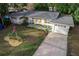 White ranch home with grey roof, wood accents, and landscaped yard at 900 Mulberry St, Fruitland Park, FL 34731