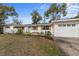 Ranch home features a white exterior, wood accents, and a landscaped yard at 900 Mulberry St, Fruitland Park, FL 34731