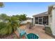 Open patio area with outdoor seating, lush palm trees, and a screened lanai in the background at 1065 Ne 31St Ter, Ocala, FL 34470
