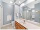 Bright bathroom featuring a large mirror, wood cabinets and tiled floors at 1065 Ne 31St Ter, Ocala, FL 34470