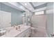 Bright bathroom featuring a spacious vanity, tiled floor, and a glass-enclosed shower/tub at 1065 Ne 31St Ter, Ocala, FL 34470
