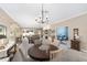 Spacious dining area with a chandelier, seamlessly flowing into the living room and kitchen, perfect for entertaining at 1065 Ne 31St Ter, Ocala, FL 34470