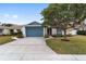 House exterior showcasing a blue door and well maintained lawn at 1065 Ne 31St Ter, Ocala, FL 34470