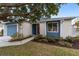 House exterior showcasing a blue door and well maintained lawn at 1065 Ne 31St Ter, Ocala, FL 34470