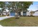 House exterior showcasing a blue door and well maintained lawn at 1065 Ne 31St Ter, Ocala, FL 34470