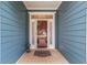 Inviting front entrance with a glass storm door, tiled porch, and a 'HOME' welcome mat at 1065 Ne 31St Ter, Ocala, FL 34470