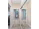 Hallway with mirrored closet doors leading to the bedroom and bathroom at 1065 Ne 31St Ter, Ocala, FL 34470
