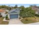 Single-story home with blue garage door and landscaped yard at 1065 Ne 31St Ter, Ocala, FL 34470