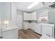 Efficient laundry room featuring modern white appliances, ample cabinetry, and wood-look floors at 1065 Ne 31St Ter, Ocala, FL 34470