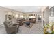 Spacious living room featuring plush carpeting, comfortable seating, and an open layout connecting to the kitchen at 1065 Ne 31St Ter, Ocala, FL 34470