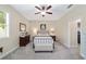 Neutral main bedroom with fan, dresser, bench and outside view from the window at 1065 Ne 31St Ter, Ocala, FL 34470