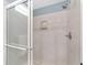 Modern tiled shower with rainfall shower head and glass door in bathroom at 1065 Ne 31St Ter, Ocala, FL 34470