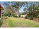 Landscaped backyard with grassy area and view of trees at 19586 Sw 84Th Pl, Dunnellon, FL 34432